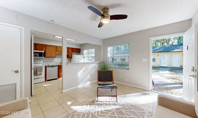 a living room with stainless steel appliances kitchen island granite countertop furniture and a fireplace
