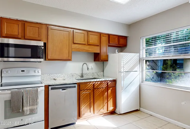 a kitchen with stainless steel appliances a stove sink and microwave
