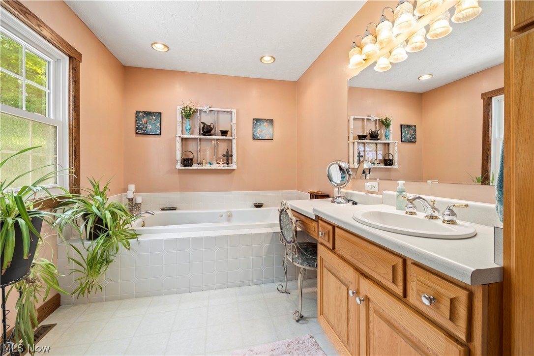 8737 River Corners Road Homerville, OH 44235 - Photo 24 of 46 Master Bathroom with tile flooring, tiled tub, and large vanity