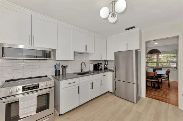a kitchen with stainless steel appliances granite countertop a sink dishwasher stove and refrigerator