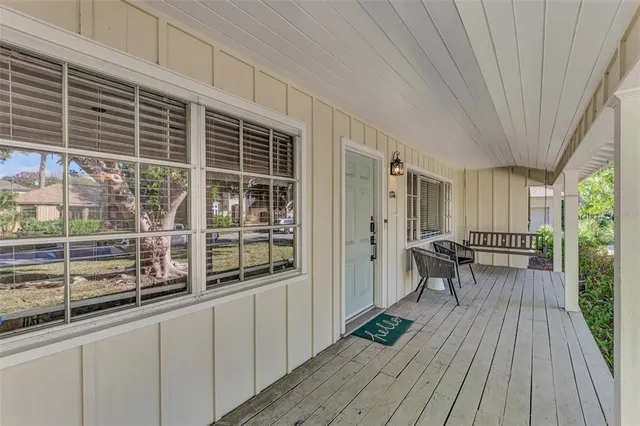 a view of a balcony with chairs and wooden floor