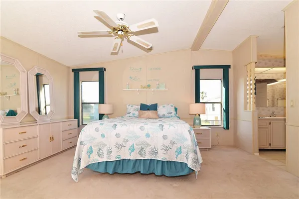 a bedroom with a large bed and a chandelier fan