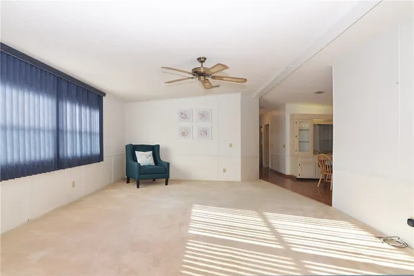 a view of a livingroom with a chandelier fan and windows