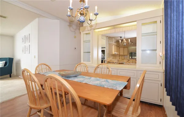 a dining room with furniture a chandelier and wooden floor