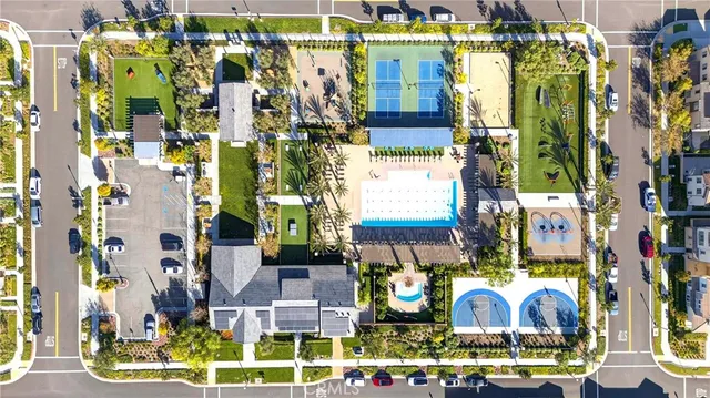 a view of a park with large trees and a cars parked in front of it