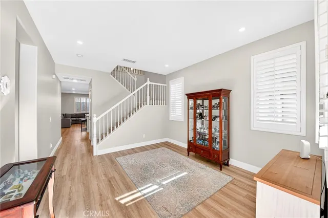 a open kitchen with stainless steel appliances granite countertop a stove top oven a sink dishwasher a dining table and chairs with wooden floor