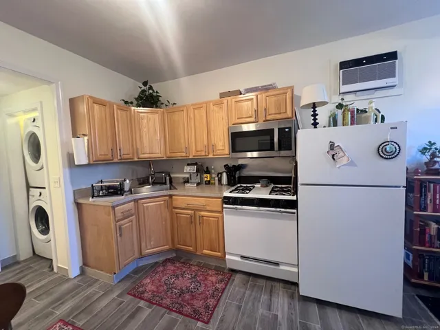 a kitchen with stainless steel appliances granite countertop a refrigerator a stove a sink and a microwave