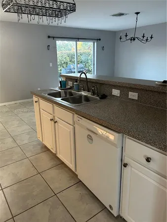 a kitchen with stainless steel appliances a sink dishwasher a refrigerator and window