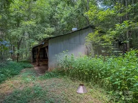an aerial view of residential house with outdoor space and trees all around