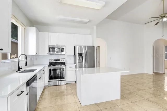 a kitchen with stainless steel appliances a refrigerator sink stove microwave and cabinets