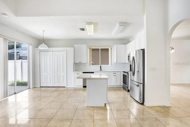 a kitchen with a refrigerator and cabinets