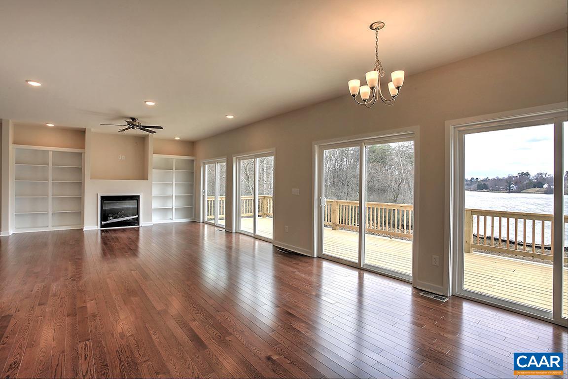 663 Pine Bluff Road Ruckersville, VA 22968 - Photo 5 of 24 an empty room with wooden floor fireplace and windows