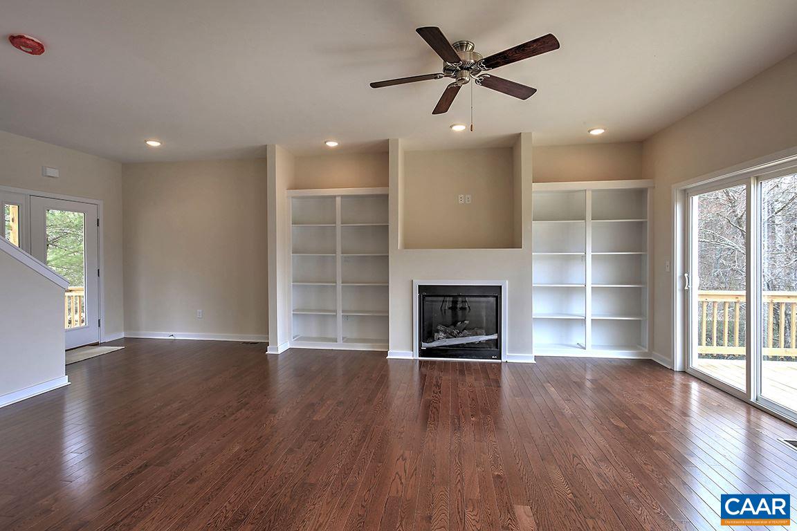 663 Pine Bluff Road Ruckersville, VA 22968 - Photo 6 of 24 an empty room with wooden floor a fireplace and windows