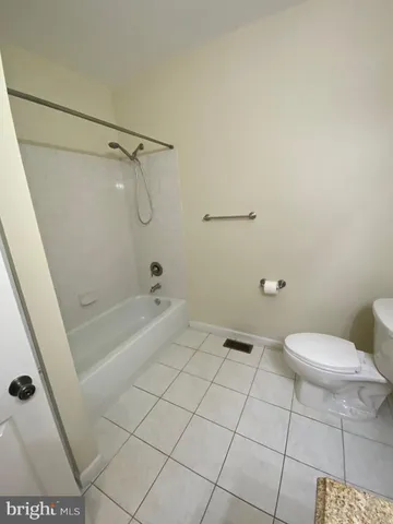 a bathroom with a granite countertop toilet a sink and shower