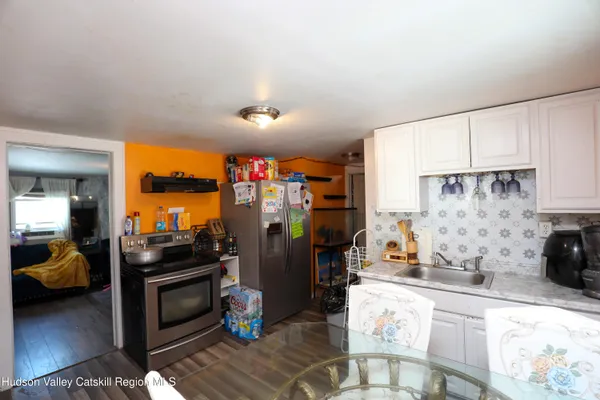 a kitchen that has a lot of cabinets a sink and appliances