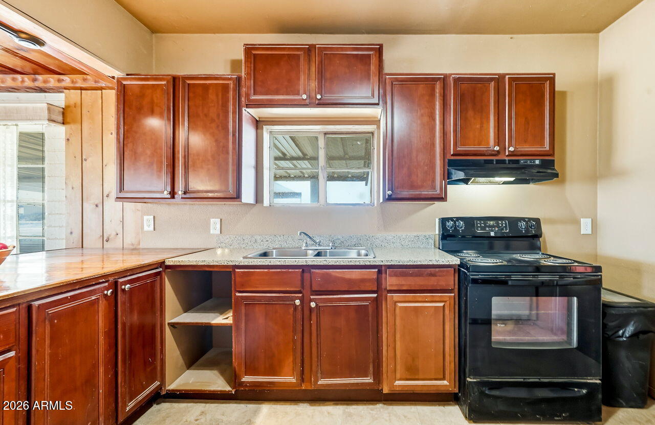 3384 East Cornman Road Casa Grande, AZ 85194 - Photo 40 of 58 a kitchen with stainless steel appliances granite countertop a stove a sink and a microwave