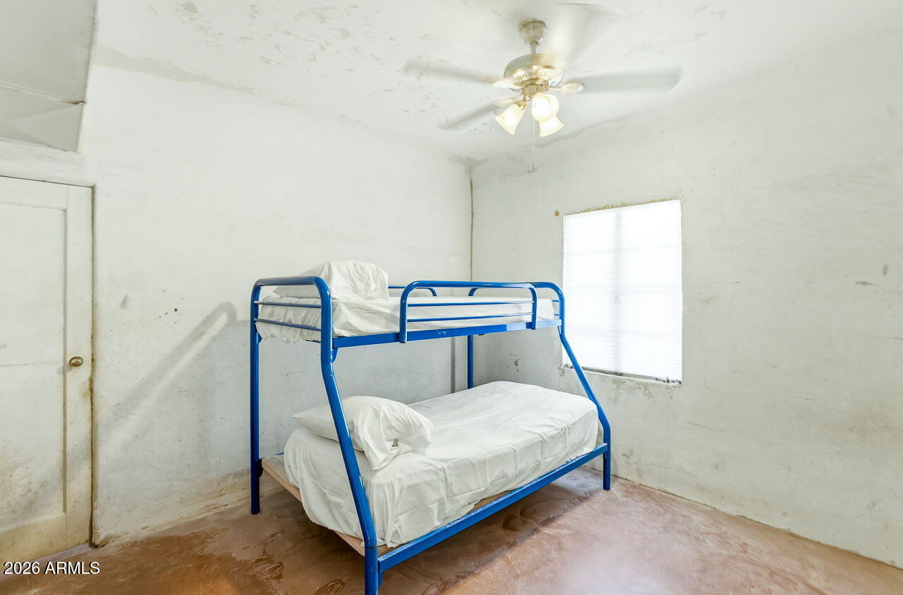3384 East Cornman Road Casa Grande, AZ 85194 - Photo 42 of 58 a bedroom with a bed a chandelier and a window