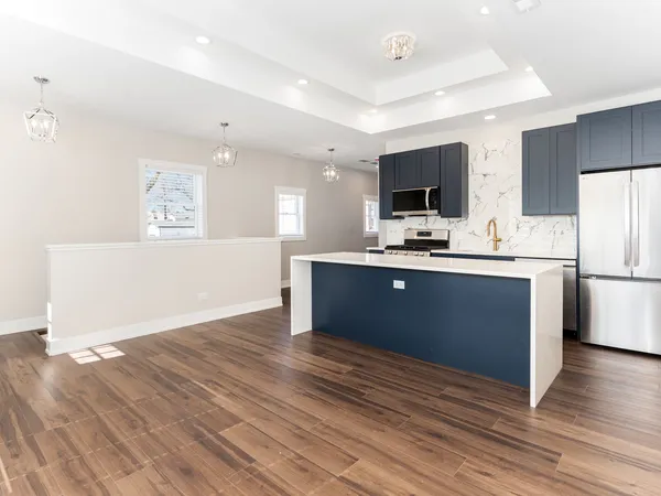 a kitchen with kitchen island a sink stainless steel appliances and cabinets