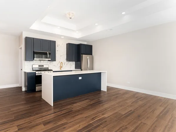 a view with kitchen island sink and refrigerator