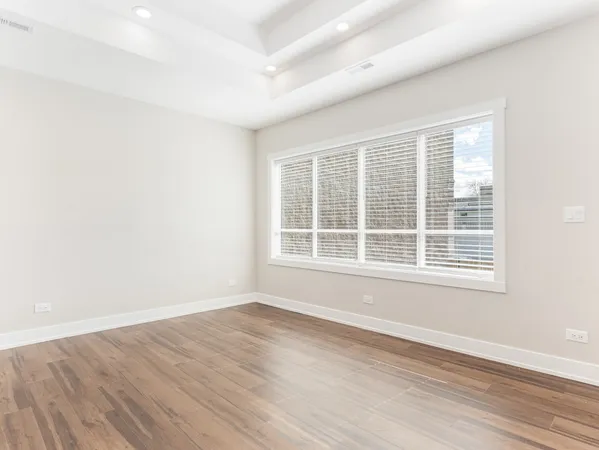 a kitchen with stainless steel appliances kitchen island granite countertop a refrigerator a sink dishwasher a stove with white cabinets and wooden floor