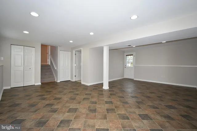a view of an empty room with wooden floor and closet area