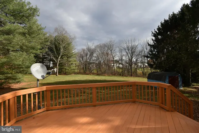 a view of a balcony with wooden floor and yard