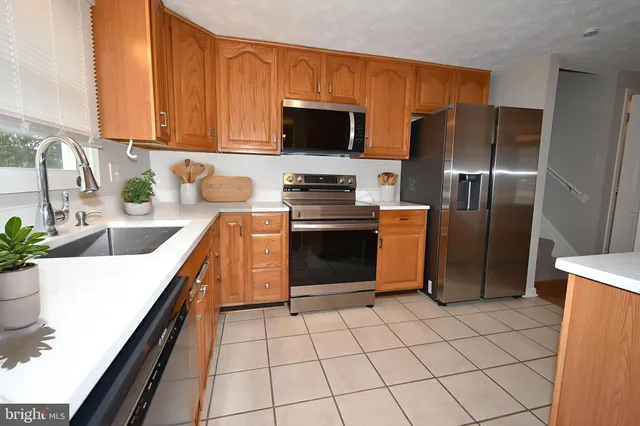 a kitchen with stainless steel appliances a stove a sink a microwave and a refrigerator