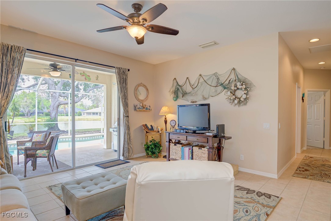 9005 Falcon Pointe Loop Fort Myers, FL 33912 - Photo 12 of 39 a living room with furniture a flat screen tv and a floor to ceiling window