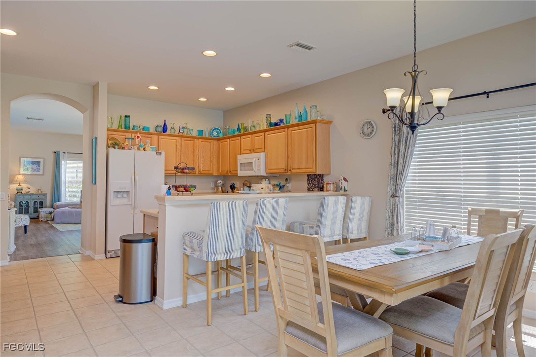 9005 Falcon Pointe Loop Fort Myers, FL 33912 - Photo 14 of 39 a kitchen with stainless steel appliances kitchen island granite countertop a table chairs and a refrigerator