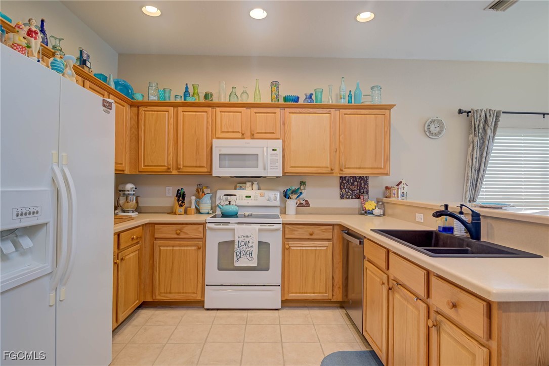 9005 Falcon Pointe Loop Fort Myers, FL 33912 - Photo 8 of 39 a kitchen with a sink window and cabinets