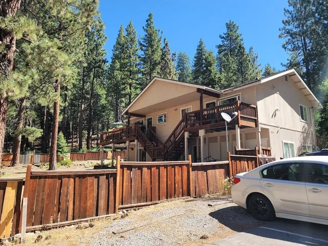a view of a white house and a car parked side of it