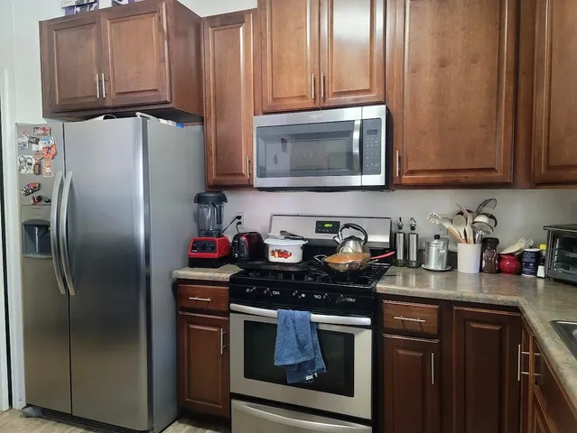 a kitchen with stainless steel appliances granite countertop a refrigerator stove and sink