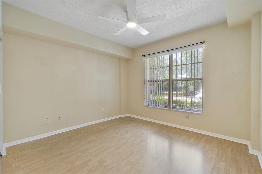 6020 West Sample Road, Unit 103 Coral Springs, FL 33067 - Photo 12 of 20 an empty room with wooden floor and windows