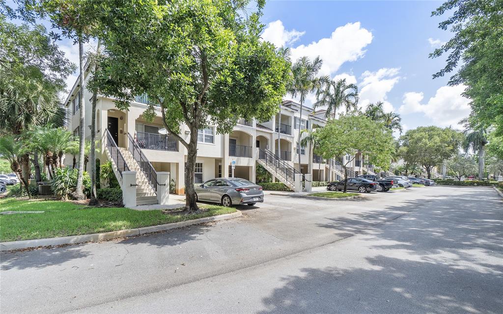 6020 West Sample Road, Unit 103 Coral Springs, FL 33067 - Photo 19 of 20 a view of a building with a bench in front of a house