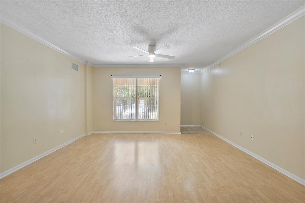 6020 West Sample Road, Unit 103 Coral Springs, FL 33067 - Photo 6 of 20 an empty room with wooden floor and windows