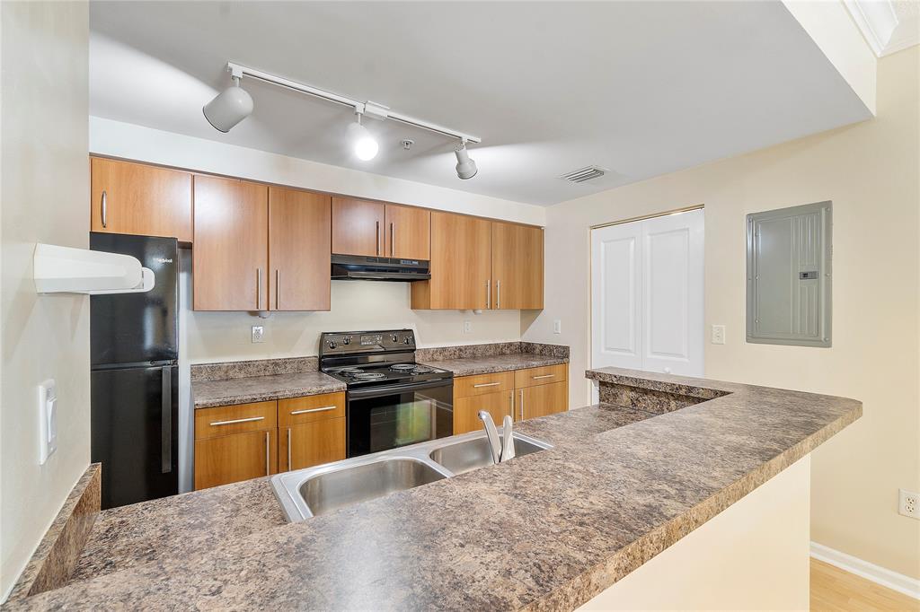 6020 West Sample Road, Unit 103 Coral Springs, FL 33067 - Photo 9 of 20 a kitchen with stainless steel appliances granite countertop a sink stove and refrigerator