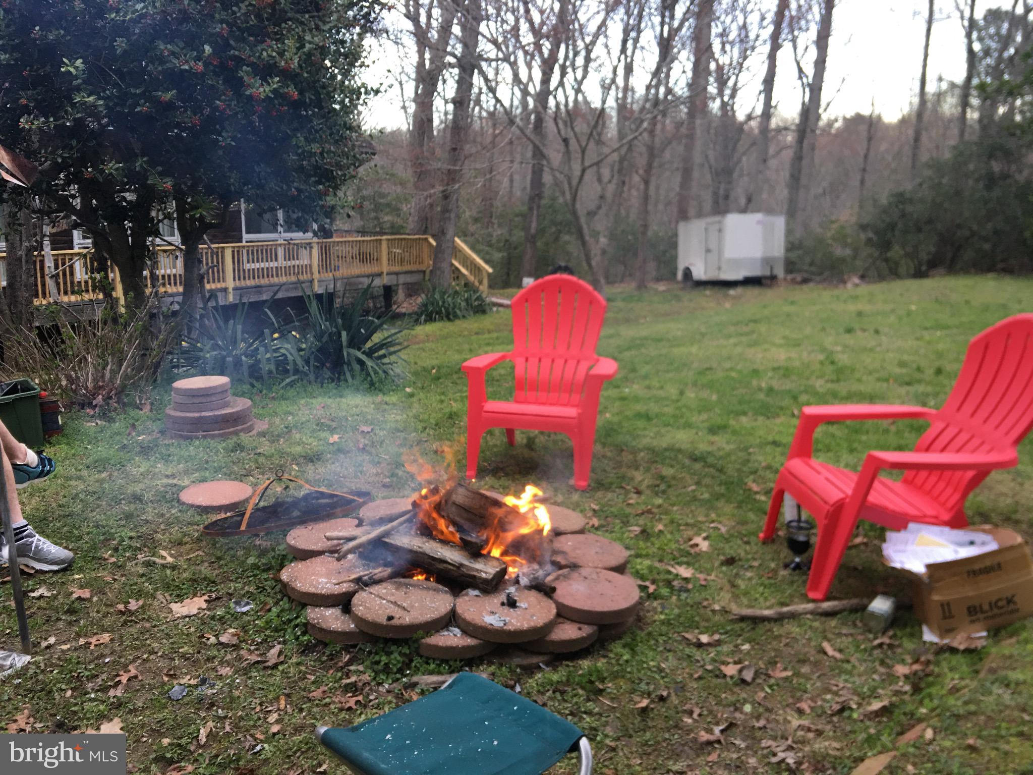 12466 Dalton Trail Lusby, MD 20657 - Photo 42 of 74 a view of a wooden chairs and fire pit in the yard