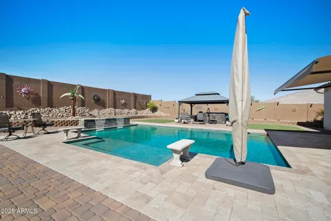 a view of swimming pool with a patio and a yard