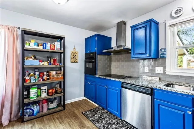 a kitchen with granite countertop wooden cabinets stainless steel appliances a sink and a window
