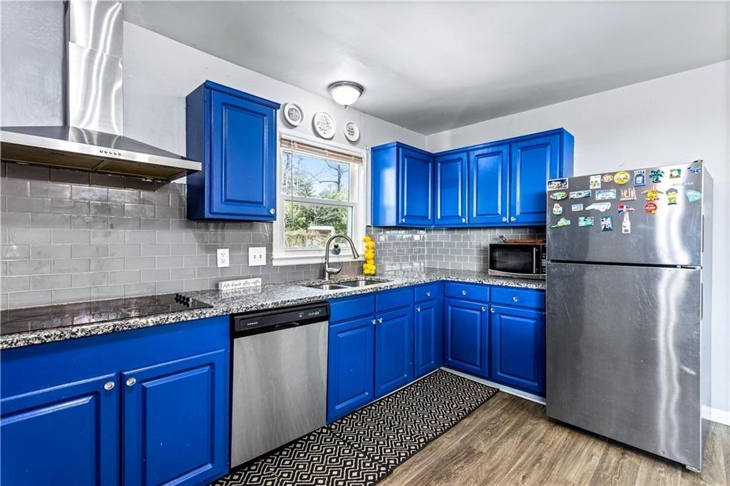 1646 Flicker Road Hampton, GA 30228 - Photo 22 of 38 a kitchen with granite countertop wooden cabinets stainless steel appliances a sink and a window