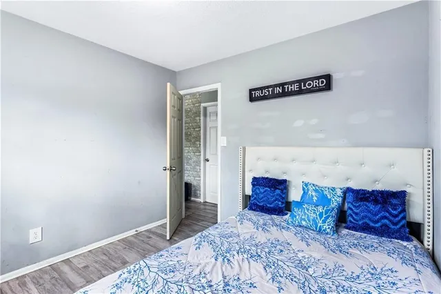 a bed sitting in a bedroom next to a window and a chandelier