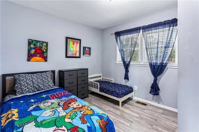 a bedroom with a bed and wooden floor