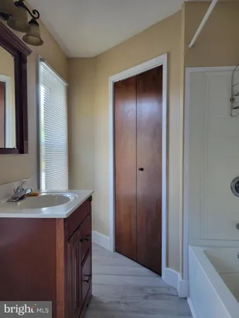 a bathroom with a granite countertop sink and a bathtub