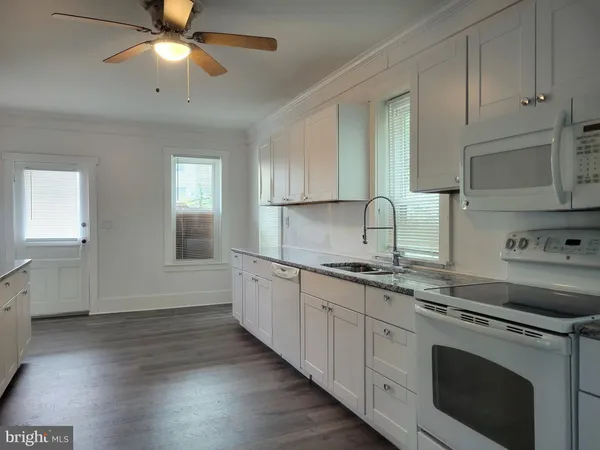 a kitchen with granite countertop a sink stainless steel appliances and cabinets