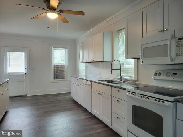 a kitchen with granite countertop a sink stainless steel appliances and cabinets