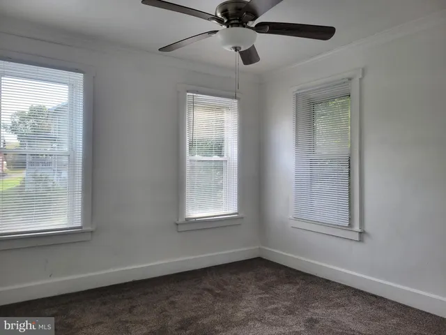an empty room with a window and a ceiling fan