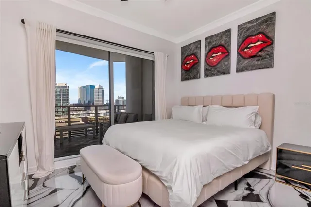 a bedroom with a bed and a flat tv screen on dresser