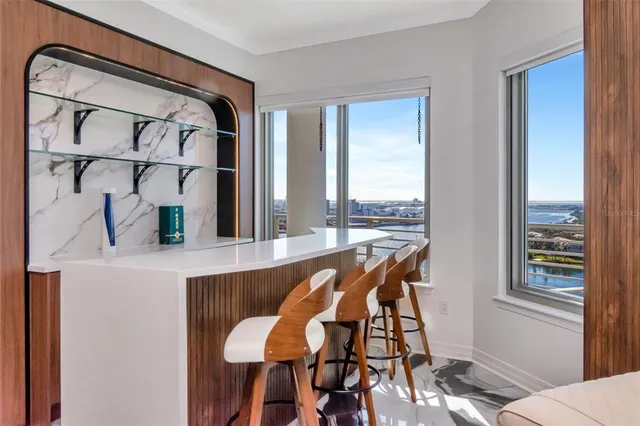 a living room with furniture kitchen view and a large window