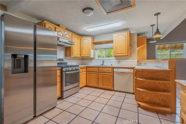 a kitchen with stainless steel appliances granite countertop a stove a sink and a refrigerator