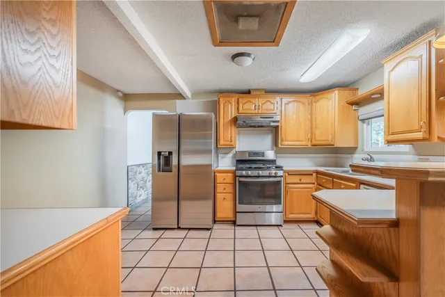 a kitchen with stainless steel appliances granite countertop a stove a sink and a refrigerator